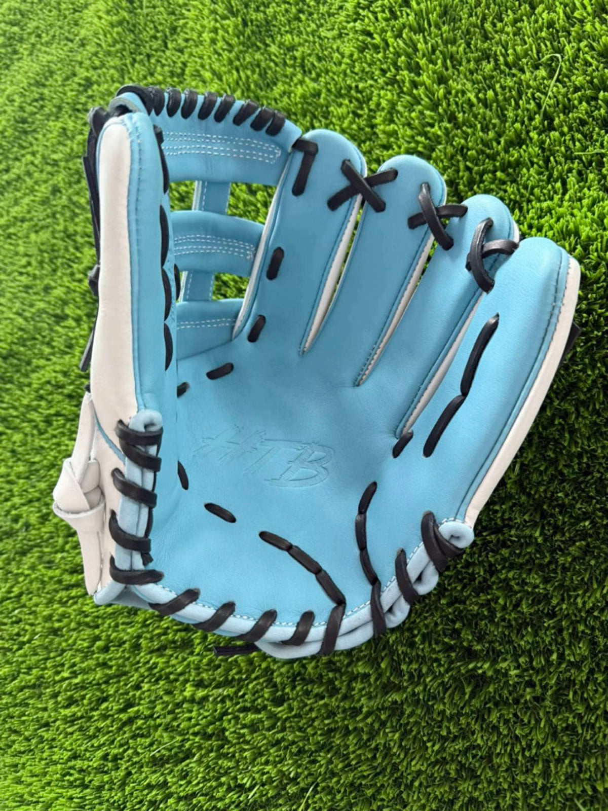 White and Columbia blue HTB Do Damage infield glove, palm view with embossed HTB logo