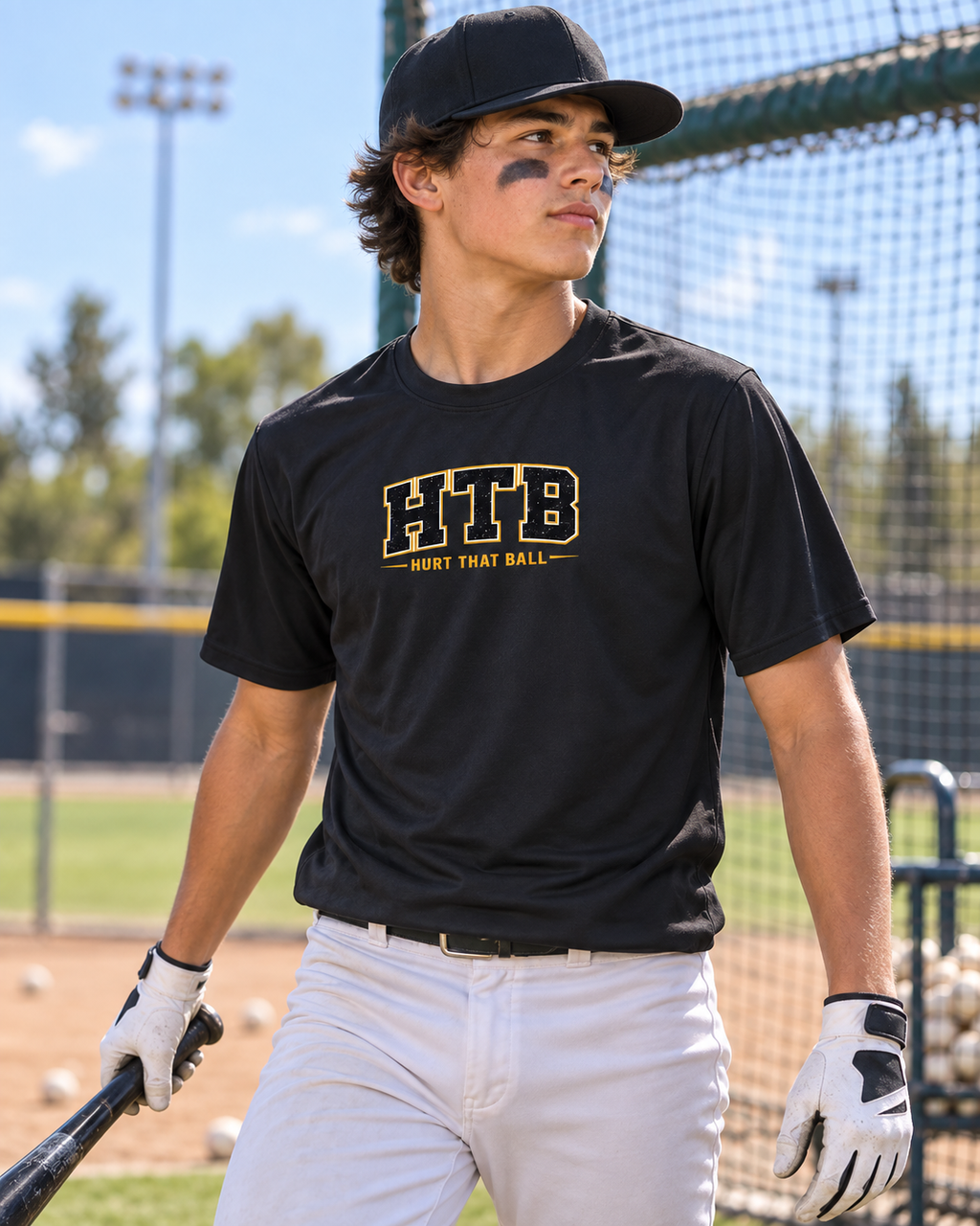 Baseball player wearing the black and gold HTB Performance Tee