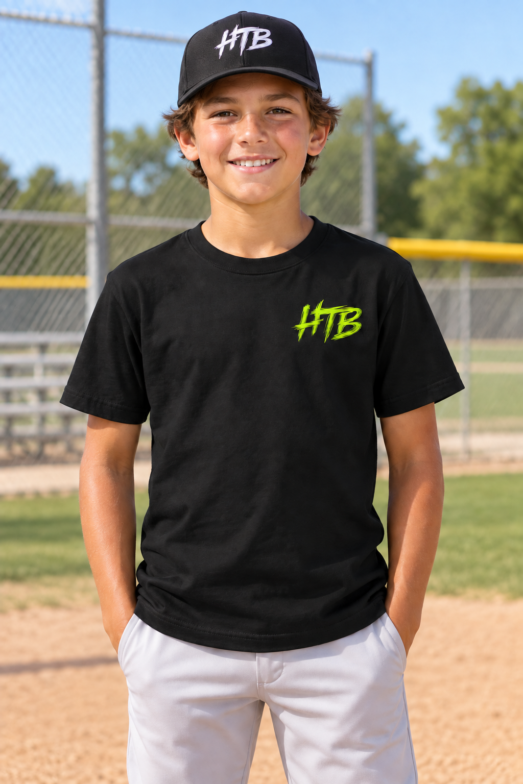 Youth baseball player wearing the black HTB Youth Signature Tee and black HTB hat, front view