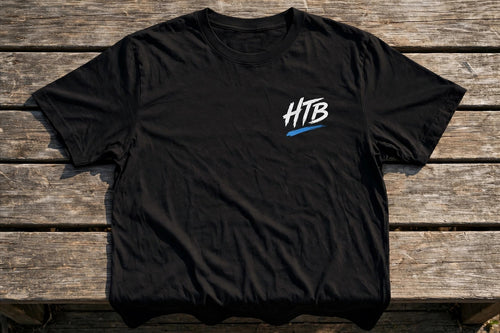 HTB Signature Tee in Black - front flat lay on a dugout bench